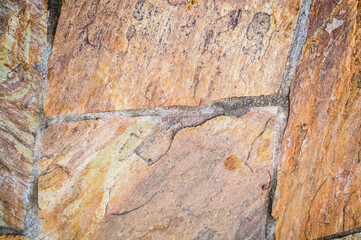 Background from paving stones. Stone pavement texture in Copper, beige and Light Gold color