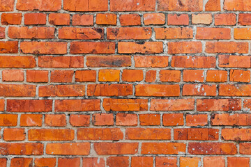 The wall is made of red ceramic bricks. Textured background with old, dirty and red bricks.