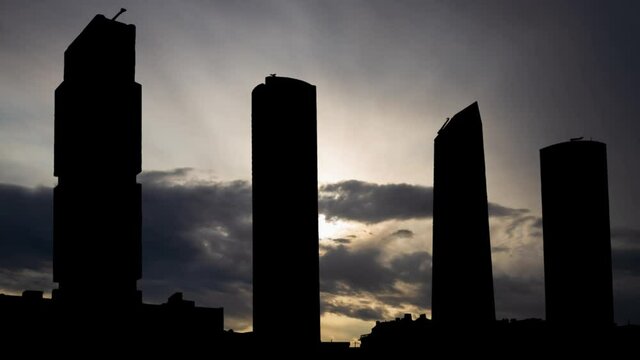 Four Towers Skyline in Madrid, Time Lapse at Sunrise with Fast Clouds and Dark Silhouette of Skyscrapers