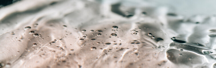 Beauty serum gel texture clear skincare cream with bubbles background