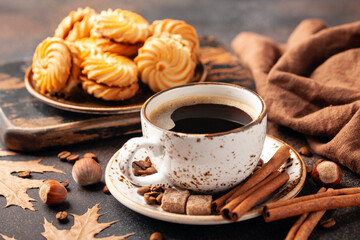 Black coffee and cookies on a table. Autumn background