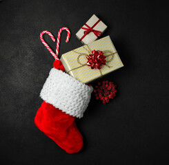 Obraz na płótnie Canvas Christmas stocking red with gifts on a black background.