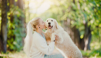 Pretty young woman love her dog, background summer park. Concept travel Friendship girl and golden retriever