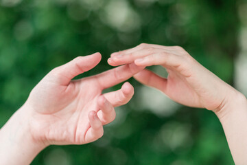 Hands of a young caucasian european and a young asian woman touching