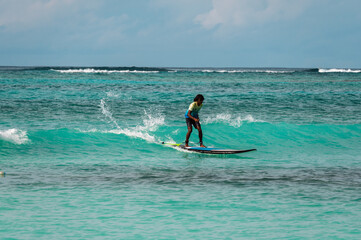 A surfer rides a board on the waves of the ocean. Water adventures in the tropics.