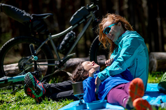 Adventurous woman with her daughter in a camping enjoying a sunny day