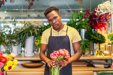 young african entrepreneur looking at the flowers of his business