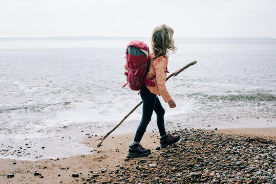 girl walking the Jurassic coast with a stick on a beautiful day in UK