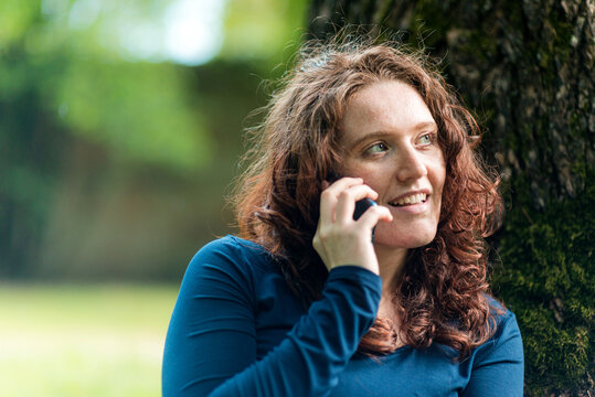 Young   woman at listening to smartphone outdoors