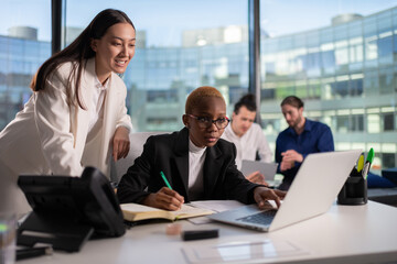 Asian businesswoman helping black colleague