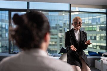 Cheerful black businesswoman talking during conference