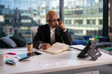 African American businesswoman making notes during phone call