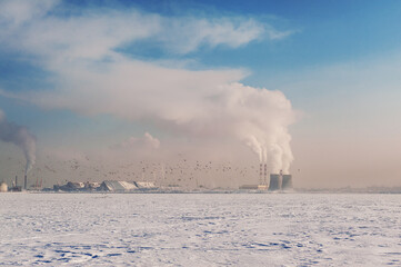 Winter city landscape with smoke of factories