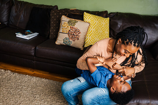 Playful mother and son in living room at home