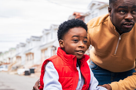 Father helping son learn to ride a bike outdoors