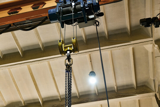The chains for lifting loads on the telpher crane lie on a wooden rack.