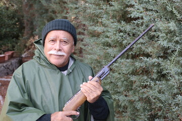 Senior hunter with a mustache in the forest 