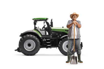 Full length portrait of a mature farmer posing with a shovel in front of a tractor