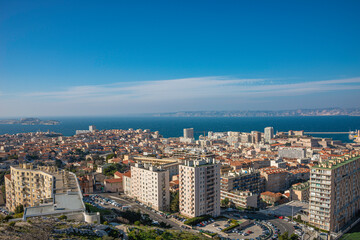 Obraz premium Panoramic bird view over modern and old center, port and suburbs in Marseille, France, at sundown and blue sky.