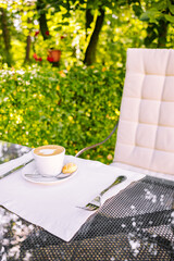 Morning breakfast. Сup of coffee on table in the garden and nature background. Cozy autumn mood.	