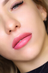 Naklejka premium close-up of the beautiful lips of a young model with a lip tattoo