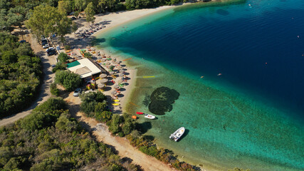 Aerial drone photo of organised with sunbeds and umbrelas paradise beach of Fanari with crystal clear turquoise sea, Meganisi island, Ionian, Greece