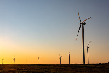General view of wind turbines in countryside landscape during sunset