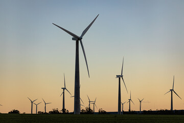 General view of wind turbines in countryside landscape with cloudless sky