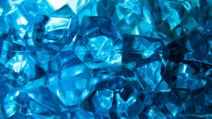 Bright blue crystals made of glass look like gems close-up in the blur. Background from blue stones...