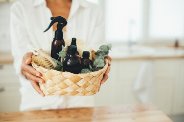 Woman holding wicker basket with natural eco-friendly zero waste plastic free cleaning items:...
