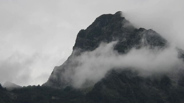peaked mountain peak in swirling clouds - cloudy summer day