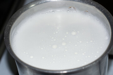 Boiling raw unpasteurized milk milk on stove top to kill any harmful bacteria 