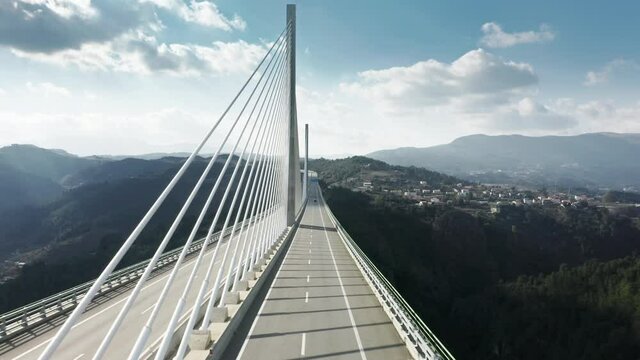 Drone flying over cars driving on road of Vila Real Bridge, Portugal, Europe. Highway bridge situated two cities. Overhead shot of autos moving on road bridge over Corgo river on sunny day, 4k footage