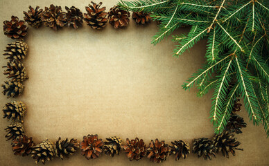 Rectangular frame made of natural pine cones and green spruce branches.New Year's background for a greeting text.