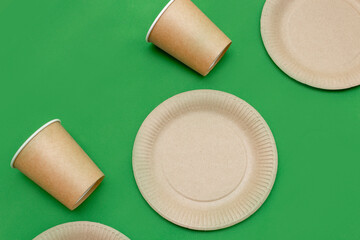 Paper plate, glass on a green background. Eco-friendly, compostable dishes, disposable, recyclable materials. Zero plastic, saving the planet, stop plastic. The concept of waste recycling