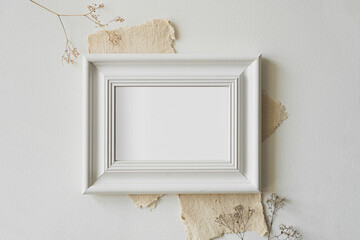 A horizontal photo frame surrounded by vintage letters lies on a white table.