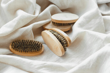 Bamboo beard brushes with natural bristles on linen textile background. Facial care concept for men. natural zero-waste