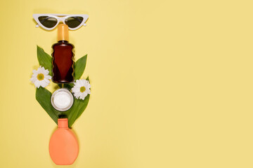 Cosmetics SPF for face and body on yellow background. Top view, flat lay