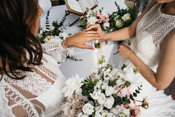 CU View of two LGBT females lesbians brides exchanging rings during wedding ceremony