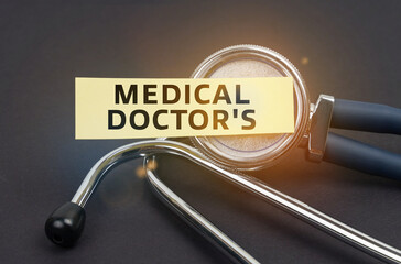 On a black background, a stethoscope, on which a sticker with the inscription - MEDICAL DOCTORS