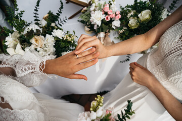 CU View of two LGBT females lesbians brides exchanging rings during wedding ceremony