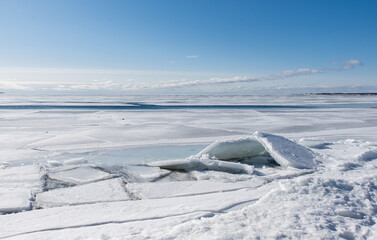 Ice formations along the shoreline of a lake on sunny winter day.