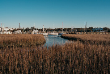 Fototapeta na wymiar water marsh view with boats and boardwalk with sunny sky