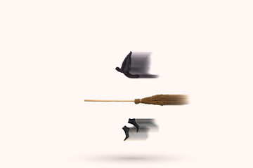 Witch hat, broomstick and shoes flying in the air. Blurred in motion. Funny invisible witch idea. Minimal abstract Halloween and horror concept.