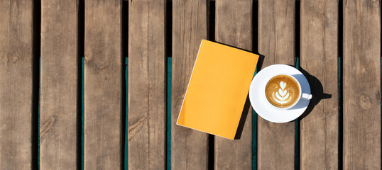 book and coffee cup on wooden background