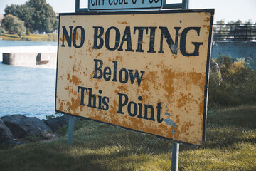 Caution signs for no swimming or boating in Idaho Falls Idaho, near the waterfall and dam of the river