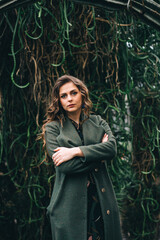 girl in a green coat in a greenhouse