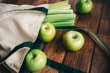 green apples and celery in an eco bag