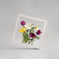 Colorful flower bouquet arranged inside square white photo frame