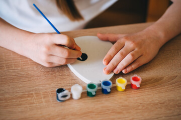 The girl paints an egg